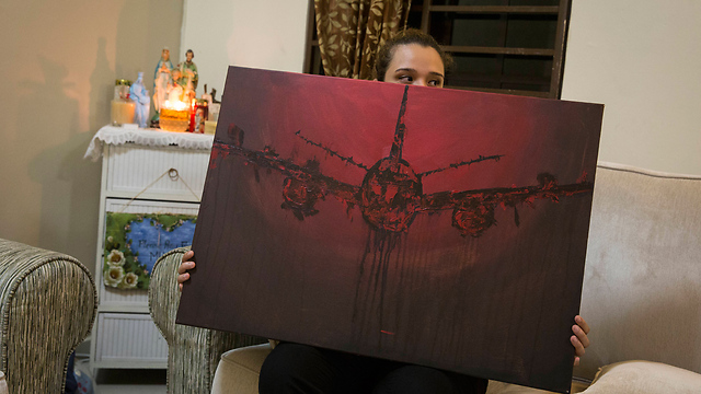 בתה של גומס מחזיקה בציור של המטוס (צילום: AP) (צילום: AP)
