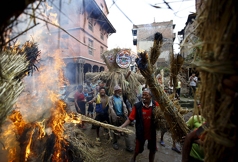 People holding figures of demons in a Nepalese festival. (Photo: Reuters)