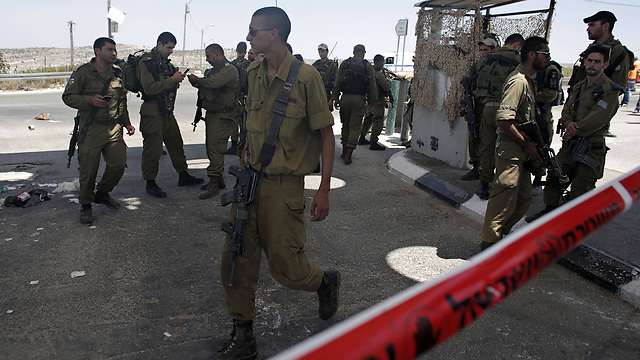 Security forces at scene of stabbing attack at checkpoint on Route 443 (Photo: AFP)