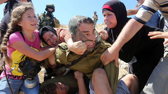 Members of the Tamimi family struggle with IDF soldier (Photo: AFP)