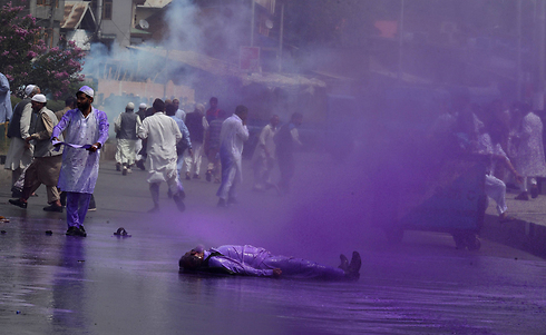 מפגין פצוע שוכב על הקרקע במהלך עימותים אלימים בעיר סרינגאר בקשמיר בין המשטרה ההודית לבין מפגינים מהאגף הניצי במפלגת All Parties Hurriyat Confrence (APHC). המפגינים מחו על מעצר מנהיגם סייד עלי שאה ג'ילאני (צילום: AFP) (צילום: AFP)