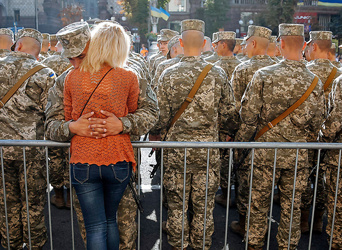 חייל מחבק את חברתו בכיכר העצמאות בקייב במהלך חגיגות יום העצמאות של אוקראינה (צילום: EPA) (צילום: EPA)