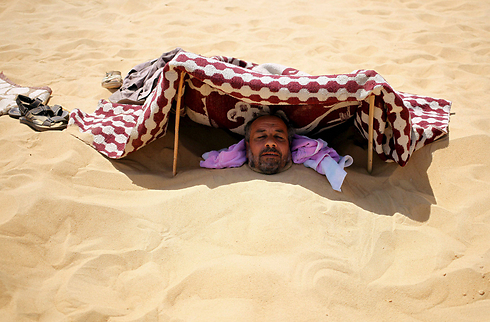 למדבר במצרים נוהרים המוני חולים עם כאבים, דלקות פרקים ואימפוטנציה כדי להיקבר בחול ב-2 בצהריים, לשתות תה חם - ואז לא להתקלח 3 ימים. וכל זאת ב-46 מעלות (צילום: רויטרס) (צילום: רויטרס)
