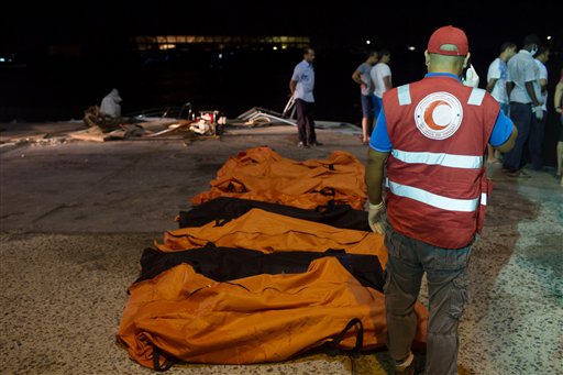 Rescue workers gather around the bodies of drowned migrants in Zuwara, Libya (Photo: AP)