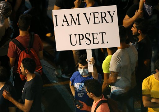 A Lebanese anti-government protester holds a placard during a demonstration (Photo: AP)