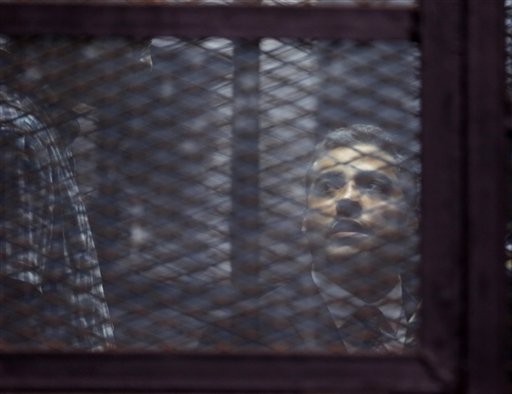 Canadian Al-Jazeera English journalist Mohammed Fahmy listens to his verdict in a soundproof glass cage inside a makeshift courtroom in Tora prison in Cairo (Photo: AP)