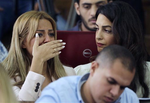 Marwa Fahmy wife of Canadian Al-Jazeera English journalist Mohammed Fahmy, bursts into tears, as she is watched by human rights lawyer Amal Clooney, after the verdict (Photo: AP)