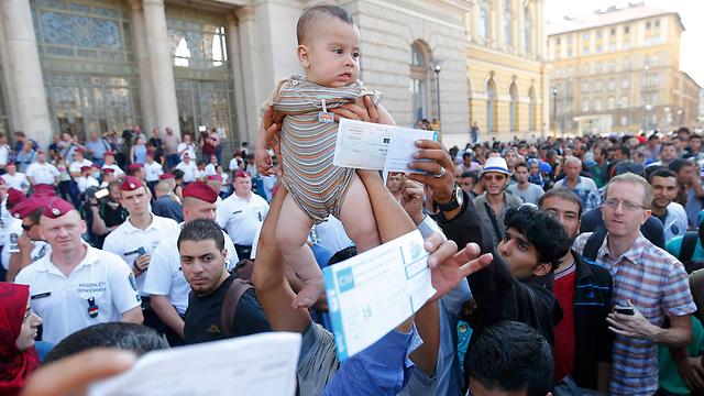 מפגינים אתמול מול תחנת הרכבת בבודפשט עם כרטיסים בידם (צילום: רויטרס) (צילום: רויטרס)