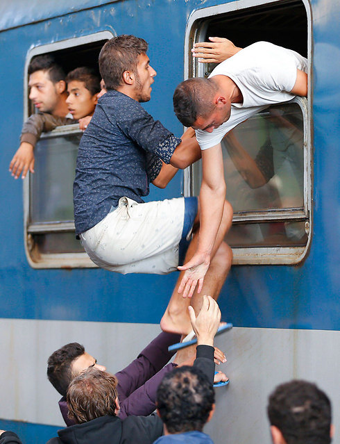 Refugees trying to get on a train in Budapest (Photo: Reuters)