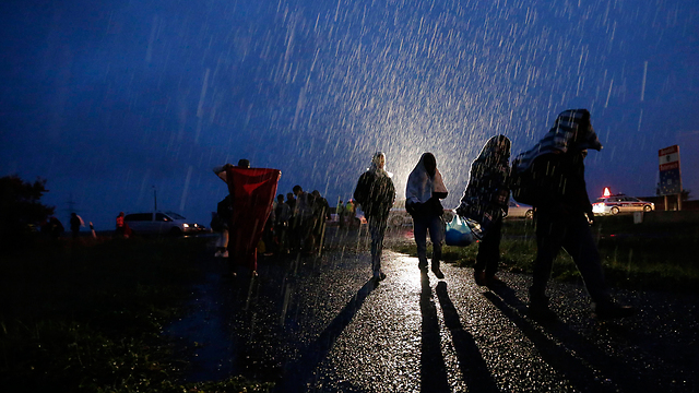 צועדים בגשם, "המשפחה שלי בסוריה פרצה בבכי של שמחה" (צילום: AP) (צילום: AP)
