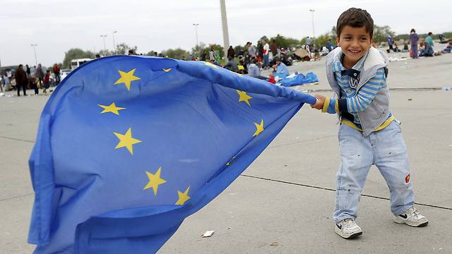 תודה לאירופה: ילד מנופף בדגל האיחוד בגבול אוסטריה (צילום: רויטרס) (צילום: רויטרס)