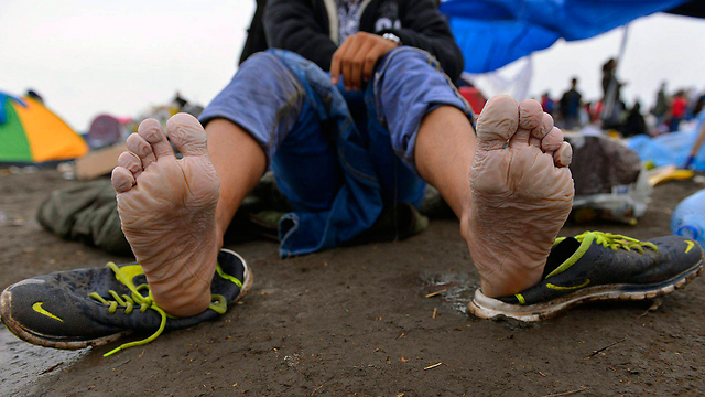 רגע של מנוחה לכפות הרגליים במחנה פליטים בהונגריה (צילום: EPA) (צילום: EPA)