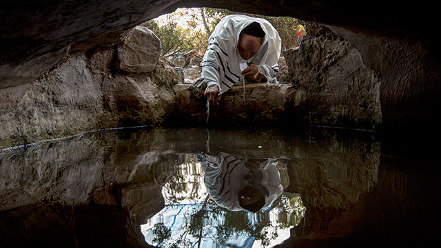 הטפטוף לא הרתיע: תפילת תשליך במערה ליד מוצא (צילום: EPA) (צילום: EPA)