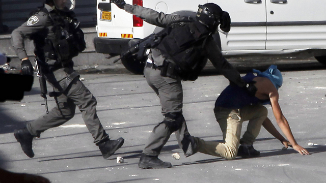 Security forces try to apprehend suspect during riots in Shuafat (Photo: AP)