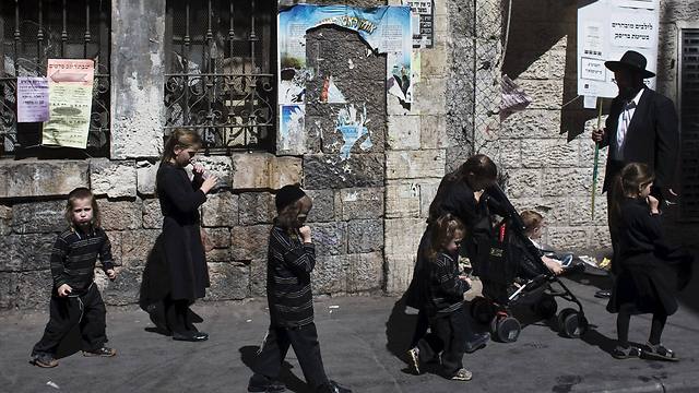 An ultra-Orthodox family walk on a street in Jerusalem's Mea Shearim neighborhood (Photo: Reuters)