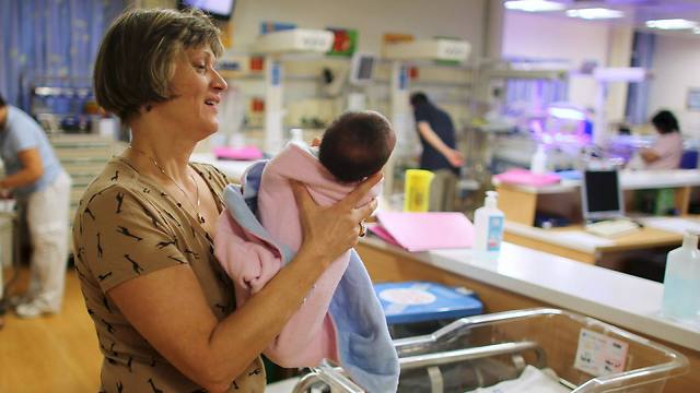 A nurse holds a newborn baby at a nursery in Hadassah Medical Center in Jerusalem (Photo: Reuters)