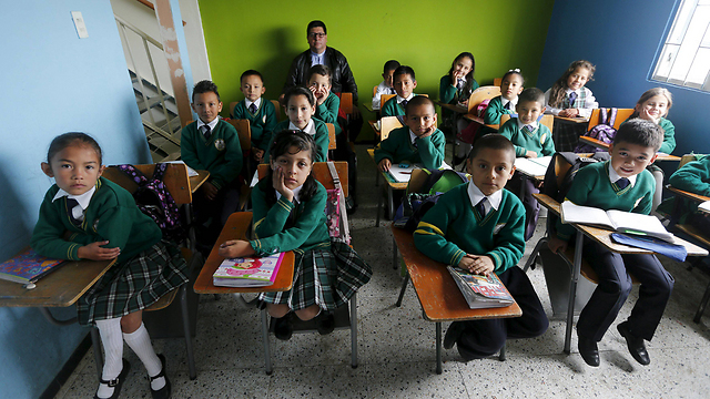 המורה, האב חואן, עם תלמידי כיתה ד' בבית הספר "זרעים של תקווה" בבוגוטה, בירת קולומביה (צילום: רויטרס) (צילום: רויטרס)