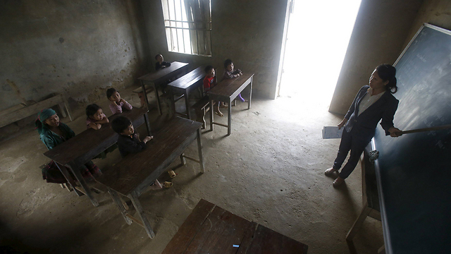 שיעור לתלמידי כיתה ג' בבית ספר בכפר במחוז דונג ואן בוייטנאם. המורה, נגוין, מלמדת בכפר שבו היא חיה 23 שנים, ללא חשמל או ספרי לימוד (צילום: רויטרס) (צילום: רויטרס)