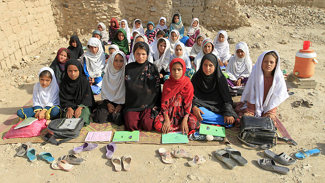 לחלק ממוסדות החינוך אין מבנים. כיתת הבנות של המורה מחג'רה לומדת בשטח פתוח בפרברי ג'ללבאד באפגניסטן (צילום: רויטרס) (צילום: רויטרס)