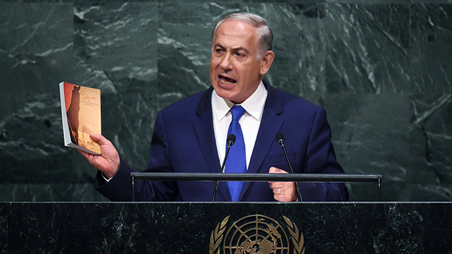 Prime Minister Benjamin Netanyahu holding Ali Khamenei's new book (Photo: AFP)