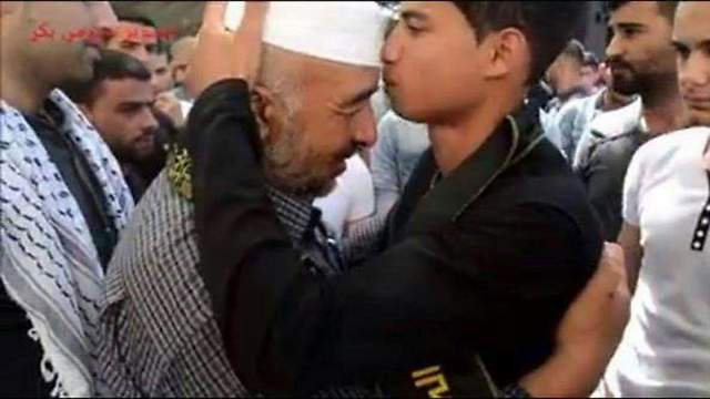 המחבל מנשק את אביו של דיא תלאחמה, הפלסטיני שנהרג ממטען שהתפוצץ לו ביד יממה לפני יום כיפור בדרום הר חברון ()