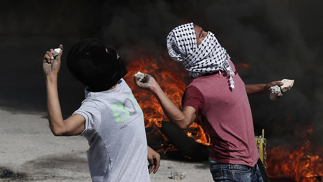 Palestinians throw rocks in clashes at Qalandiya. (Photo: AFP)
