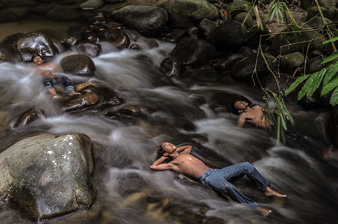 נערים מלזים מתקררים בנהר בזמן שבתי הספר במחוז הולו לנגאט סגורים בגלל ערפל כבד. מלזיה סובלת כבר שבועות מזיהום כבד בעקבות שריפות באינדונזיה השכנה (צילום: AFP) (צילום: AFP)