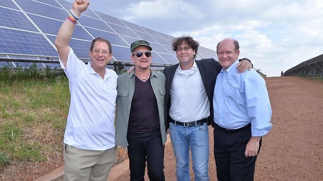 יוסף אברמוביץ (משמאל) יחד עם בונו סולן U2 בשדה הסולארי ברואנדה ()