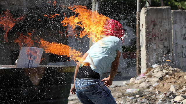 פעולת הטרור הסתבכה. הצעיר שעלה באש (צילום: AFP) (צילום: AFP)