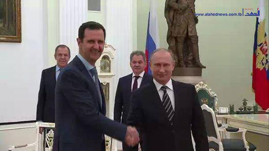 Assad and Putin shake hands during a meeting in Moscow. (Photo: Screenshot from Al-Ahed News)