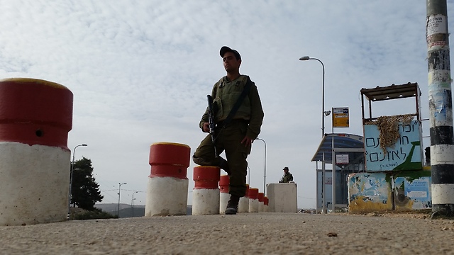 Armed soldiers stand guard at Gush Etzion junction. (Photo: Eli Mendelbaum)