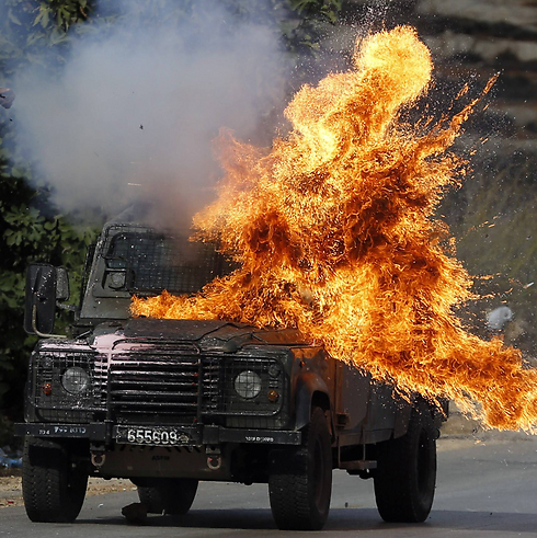 A firebomb hits a border police jeep (Photo:AFP)
