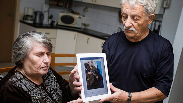 סבו וסבתו של לוחם מג"ב שמת מפצעיו עם תמונתו (צילום: גיל נחושתן, "ידיעות אחרונות") (צילום: גיל נחושתן, 