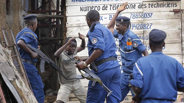 שוטרים תוקפים ילד במהלך הפגנה בבירה בוג'ומבורה (צילום: EPA) (צילום: EPA)