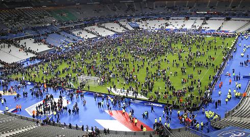 הקהל באיצטדיון סטאד דה פראנס יורד לדשא בתום המשחק, כדי לא לצאת העירה (צילום: AP) (צילום: AP)