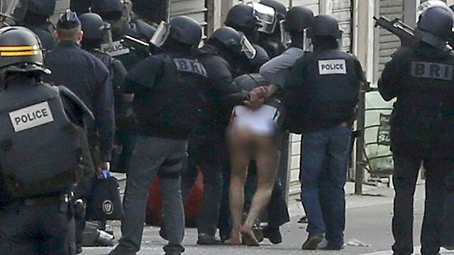 Police take one suspect into custody, naked from the waist down. (Photo: Reuters)