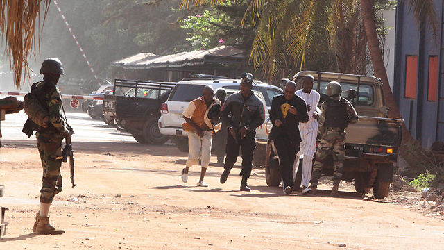 People escape from the Radisson Blu hotel in Mali capital Bamako, during an ongoing hostage situation. (Photo: AP)