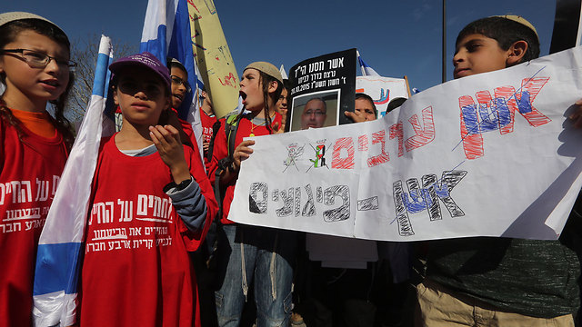 Protesters hold a sign that says 'No Arabs, no terror attacks' (Photo: Gil Yohanan)