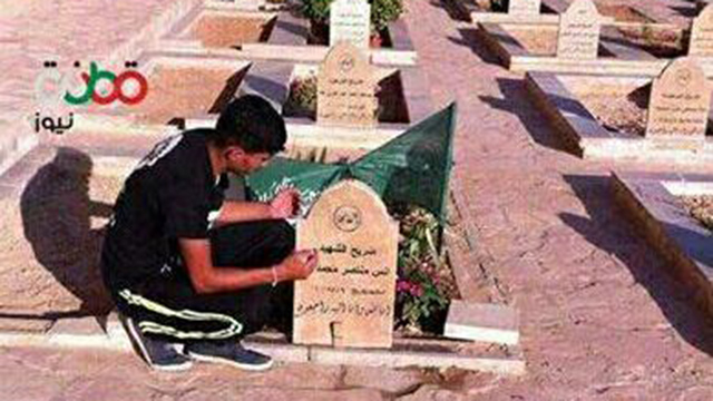 Yehya Taha, who was killed after throwing Molotov cocktail at IDF troops, praying over the grave of Anes Tah from Qattana, who committed a stabbing attack in August.