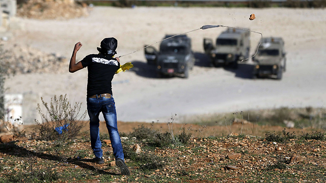 Palestinian rioters throw rocks at troops (Photo: AFP)