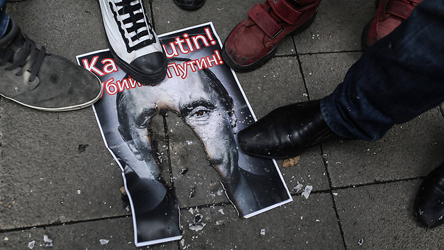 מפגינים טורקים קורעים ורומסים את תמונתו של נשיא רוסיה פוטין (צילום: AFP) (צילום: AFP)