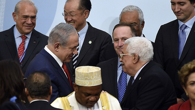 PM Benjamin Netanyahu and PA President Mahmoud Abbas meet at the 2015 UN Climate Change Conference (Photo: AFP)