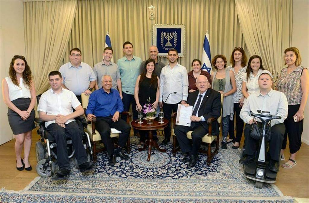 מתנדבי סיכוי שווה עם נשיא המדינה, ראובן ריבלין (פארג' בחולצה שחורה באמצע, הלמן יושב עם חולצה כחולה) (באדיבות סיכוי שווה) (באדיבות סיכוי שווה)