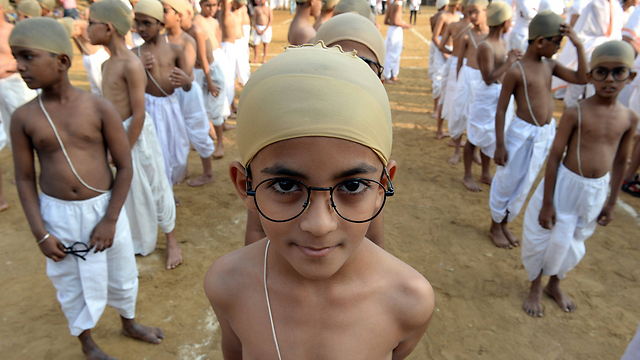 ילדים הודים לבושים בבגדי אבי האומה מהטמה גנדי במומבאי. כאלף ילדים השתתפו באירוע לקידום האידיאולוגיה של גנדי של הפצת המסר של חיים פשוטים ולצמצם את הצריכה והבזבזנות (צילום: AFP) (צילום: AFP)