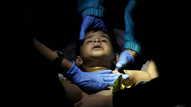 רופאים מבצעים ניסיונות החייאה בילד אחרי שסירת מהגרים טבעה בים האגאי בדרך מטורקיה (צילום: רויטרס) (צילום: רויטרס)