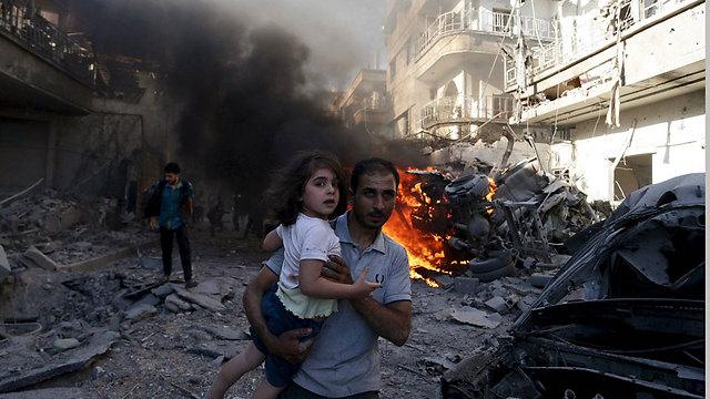 אב ממלט את בתו מיעד של אחת ההפצצות של צבא אסד בדומא, פרבר של דמשק (צילום: רויטרס) (צילום: רויטרס)