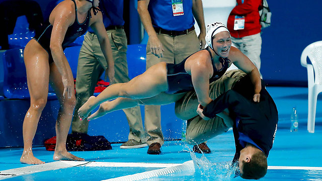 שחקניות הכדורמים של נבחרת ארה"ב דוחפות את המאמן למים אחרי זכייה במדליית הזהב באליפות העולם (צילום: רויטרס) (צילום: רויטרס)