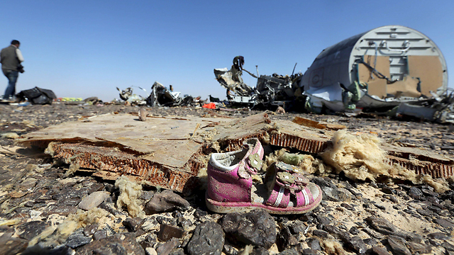 נעל של ילדה ליד הריסות המטוס הרוסי שהתרסק בסיני, כנראה בגלל פצצה שהטמין בו דאעש (צילום: רויטרס) (צילום: רויטרס)