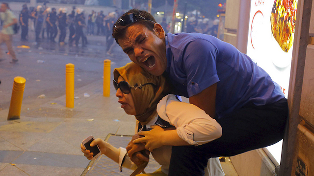 בני זוג שנפגעו מגז מדמיע בהפגנה שפוזרה על-ידי המשטרה באיסטנבול, טורקיה (צילום: רויטרס) (צילום: רויטרס)