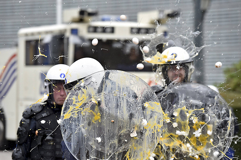שוטרים הודפים חקלאים שבאו להפגין והשליך ביצים מול מטה האיחוד האירופי בבריסל (צילום: רויטרס) (צילום: רויטרס)